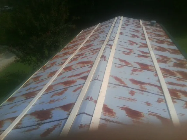 Rusted metal roof panels with new wood purlins before replacement — Storm Damage Roof Repair in Evart by Roofing Brothers